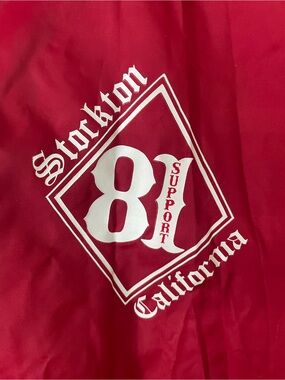 Red Lightweight Coach Rain Jacket with Stockton Support 81" logo on the chest.